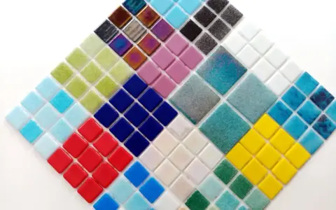 Mosaico de teselas de gresite en forma de rombo, con colores vibrantes como azul, verde, rojo, amarillo y tonos iridiscentes.