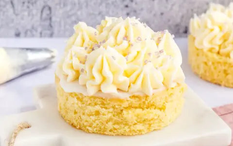 Kleiner Kuchen mit Buttercreme ohne Pudding, verziert mit lila Zuckerstreuseln.