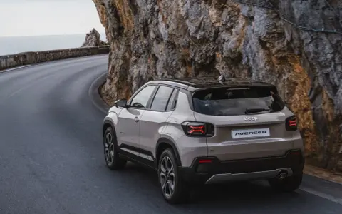 Nowy Jeep Avenger, jeden z najnowszych jeep modele, pokonuje krętą drogę nad morzem, wspinając się po skalistym zboczu.