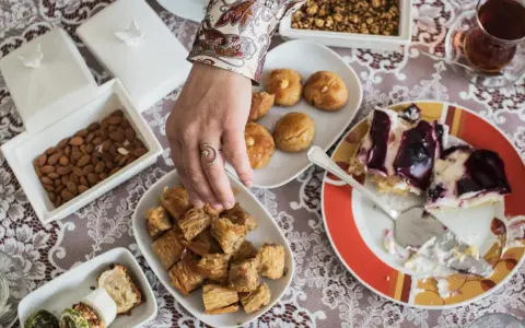 Ein Tisch voller Köstlichkeiten für das Ramadan Fest: Baklava, Kekse, Mandeln und ein Stück Kuchen.