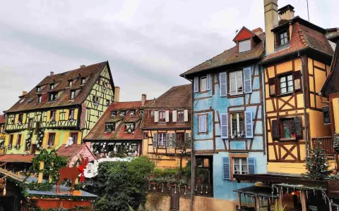 Case colorate e a graticcio lungo un canale, un'incantevole scena tra le città europee da visitare, con decorazioni natalizie.