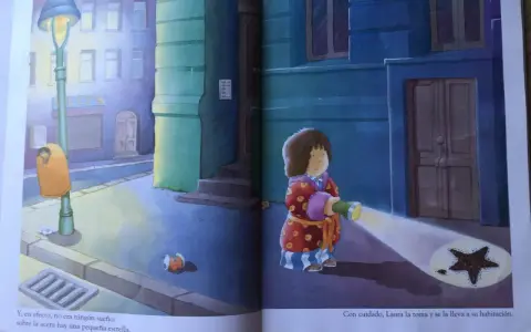 Laura, protagonista de "la estrella de laura cuento", ilumina con su linterna una estrella caída en la acera.