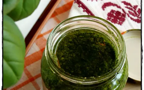 Słoik domowego pesto z bazylii, obok świeże liście. Idealne do makaronu!