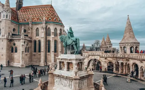 Budapeszt ceny: Rynek z pomnikiem konnym i Kościołem Macieja. Turyści zwiedzają zamek.