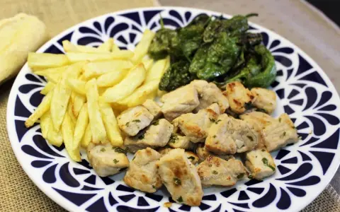 Raxo gallego con patatas fritas y pimientos de Padrón. Un plato contundente y delicioso.