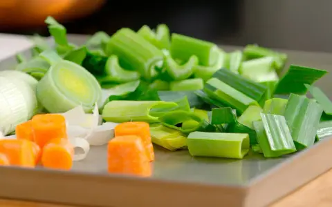 Carote, porri e sedano tagliati a pezzi, ingredienti perfetti per imparare come fare brodo vegetale.