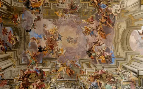 Un plafond spectaculaire dans le style baroque, peuplé d'anges et de figures célestes dans un tourbillon de couleurs et de mouvement.