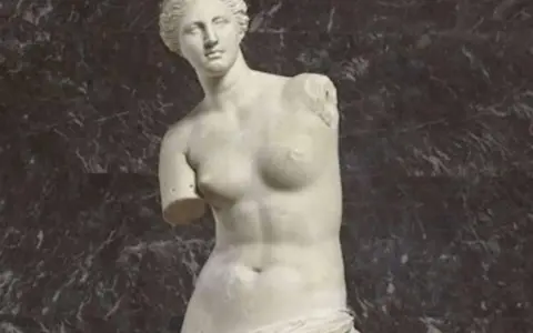 La Vénus de Milo, une sculpture antique en marbre, est représentée ici avec ses bras manquants, posant gracieusement.