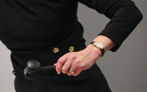 Auctioneer's hand with a gavel, ready to finalize an art loan.
