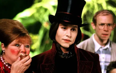 Johnny Depp jako Willy Wonka w filmie. Obok niego Veruca Salt i jej ojciec.