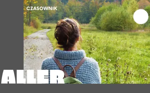 Osoby po francusku, spacerujące jesienną alejką wśród kolorowych drzew.