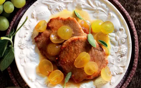 Scaloppine al vino bianco con uva dorata e salvia, un piatto succulento e profumato.