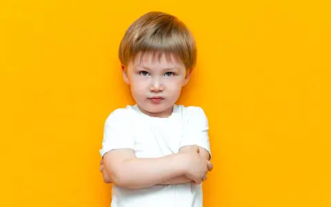 Mały chłopiec z założonymi rękami, wyrażający bunt 4 latka. Jego mina mówi wszystko.