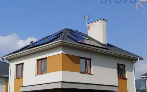 Nowy dom z panelami fotowoltaicznymi na dachu, korzystający z systemu net metering.
