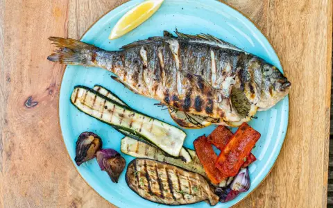 Gegrillte Dorade mit Zucchini, Aubergine, Paprika und Zwiebeln. Der frische Zitronenschnitz verspricht den vollen Dorade Geschmack.