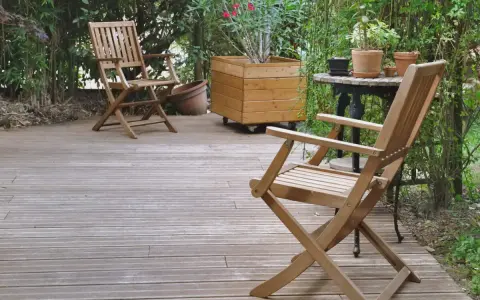 Deux chaises en bois sur une terrasse. Pour savoir comment protéger un meuble de l'humidité, pensez à un traitement hydrofuge.