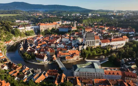 Widok na malowniczy Czeski Krumlov, gdzie rzeka Vltava otacza zabytkowe centrum z zamkiem i kościołem. To idealne miejsce, by odkrywać czeski krumlov atrakcje.