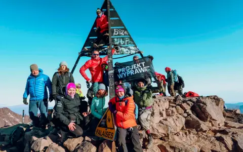Grupa zdobywców na szczycie Jabal Toubkal, z flagą "PROJEKT WYPRAWA.PL".