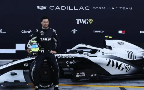Checo Pérez posa junto a un coche de F1 de Cadillac.