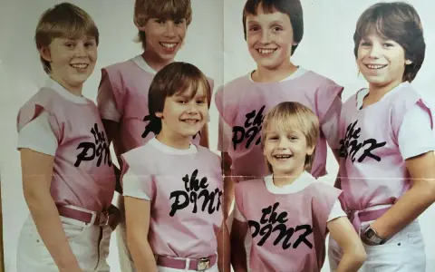 Sex glada pojkar i rosa tröjor med texten "the Pink" på. De ser ut att vara medlemmar i ett band.