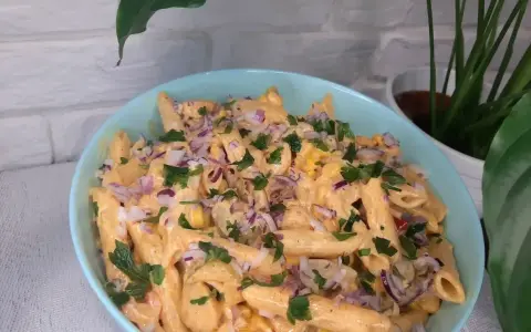 Penne z sosem gyros, kukurydzą i czerwoną cebulą, posypane natką pietruszki. Pyszna sałatka gyros z makaronem.