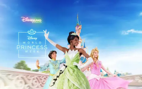 Drei Disney Prinzessinnen, Tiana, Jasmine und Aurora, tanzen vor dem Schloss in Disneyland Paris.