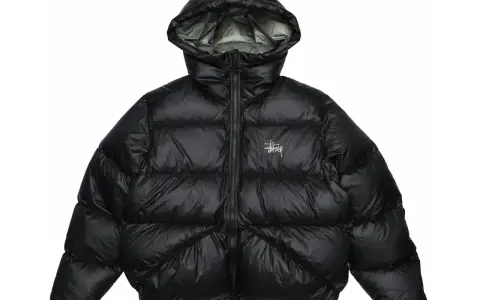 Piumino nero Stussy con cappuccio e logo bianco sul petto. Perfetto per affrontare il freddo con stile.