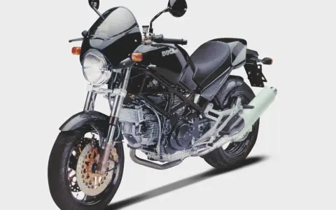 Czarny Ducati Monster z owiewką i sportowym wydechem. Klasyka motoryzacji, która wciąż budzi emocje.