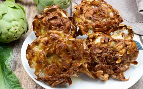 Un piatto di croccanti carciofi alla giudia, dorati e salati, pronti per essere gustati.