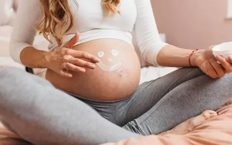 Ciężarna kobieta rysuje uśmiechniętą buźkę na brzuchu. Myśli o przyszłości, o zdrowiu dziecka i o tym, jak cenna jest krew pępowinowa.