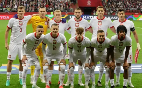 Piłkarze reprezentacji Polski w białych strojach, gotowi do gry. Wszyscy z orzełkiem na piersi, czekają na dobry wynik Polska.