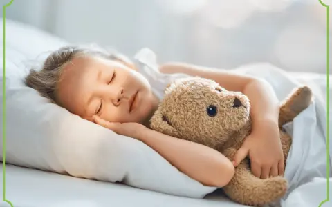 Słodki sen malucha z pluszowym misiem. Dziecko śpi spokojnie, otulone kołdrą, a jego najlepszy przyjaciel czuwa. Idealny obrazek dla dzieci.