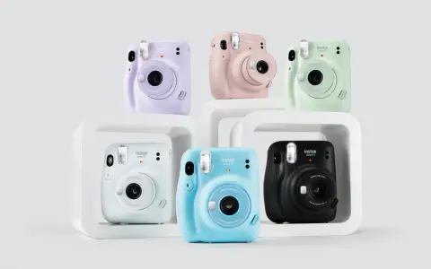 Pięć aparatów Instax Mini 11 w różnych kolorach: fioletowym, różowym, zielonym, białym, niebieskim i czarnym.