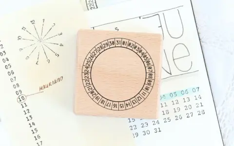 Holzstempel mit Kreis und Zahlen für den koptischen Kalender, daneben eine handgezeichnete Monatsübersicht.