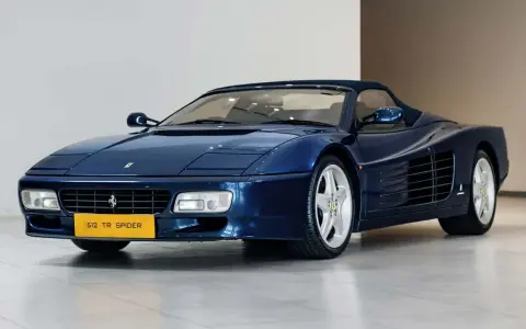 Niebieskie Ferrari 512 TR Spider z lat 90. błyszczy na wystawie, gotowe na przejażdżkę.