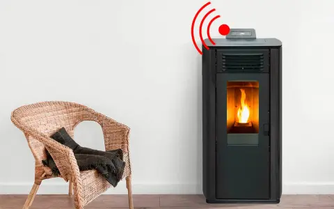 Estufa de pellets con llama encendida y señal de alarma. Junto a una silla de mimbre con manta.