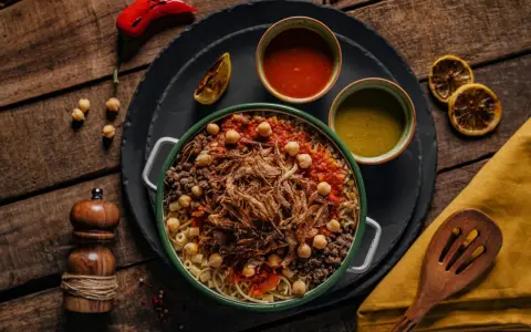 Kushari, narodowe danie kuchni egipskiej, z makaronem, ryżem, soczewicą, ciecierzycą, sosem pomidorowym i chrupiącą cebulką.