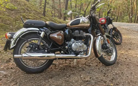 Royal Enfield Classic 350 dane techniczne: brązowy motocykl w lesie, obok czerwony. Klasyka i moc.