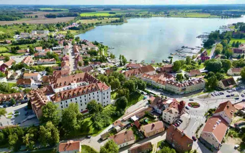 Widok z lotu ptaka na miasteczko nad jeziorem, z zamkiem i mariną. Idealne miejsce, gdzie na Mazury.