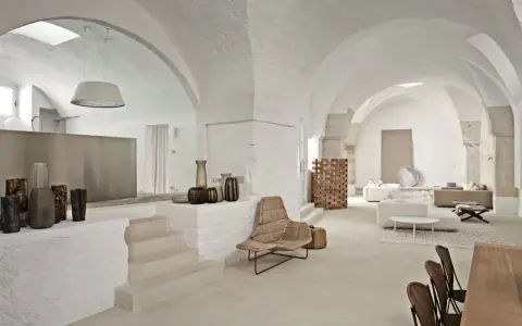 Interni moderni con volte a stella, arredi minimalisti e vasi decorativi.