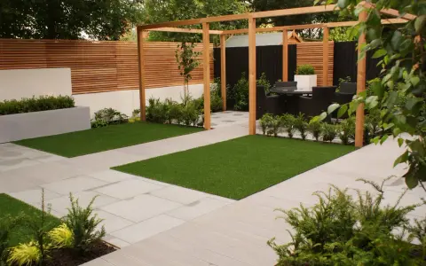 Un giardino moderno e cool con prato artificiale, pavimentazione chiara e pergolato in legno. Ideale per rilassarsi.