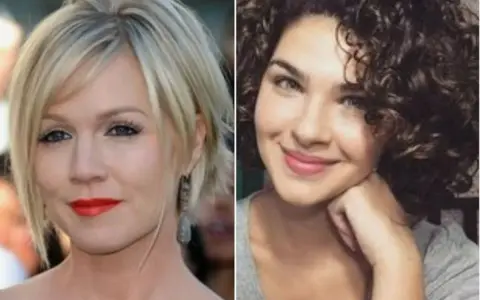 Dos mujeres. Una con pelo corto rubio y cara redonda, labios rojos. Otra con pelo rizado oscuro y cara redonda.