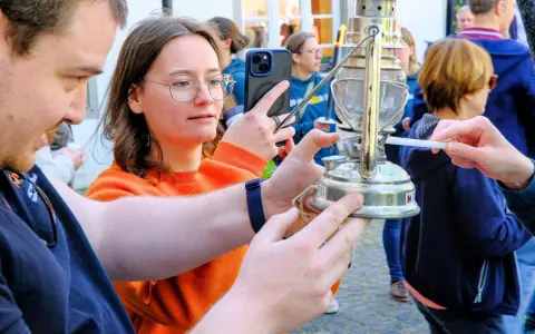 Eine Frau hält ein Handy, während eine Kerze das altenberger licht entzündet.