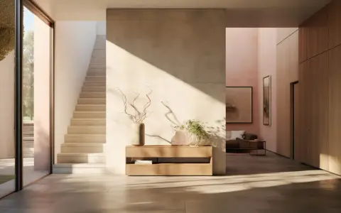 Ingresso moderno con pareti dipinte particolari, scala in pietra e arredi minimalisti. La luce solare crea giochi d'ombra suggestivi.