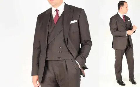 A man in a dark pinstripe suit, white shirt, and red patterned tie. He's adjusting his cuff, ready for a formal event.