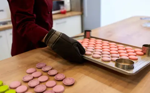 Préparation pour la cuisson macaron chaleur tournante : une plaque de macarons roses et roses est sortie du four.