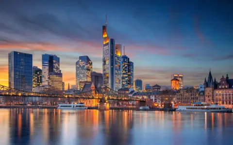 Frankfurter Skyline bei Sonnenuntergang mit Main und Brücke.