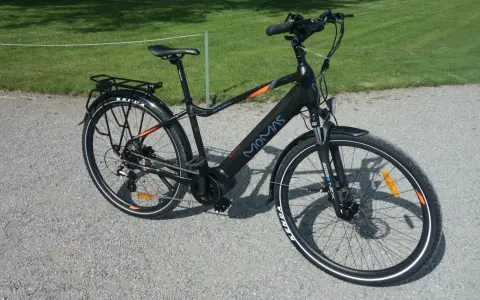 Svart elcykel, modell MOMAS JASON URBAN, redo för ett momas elcykel test. Ställning bak, skärmar och reflexer syns tydligt.