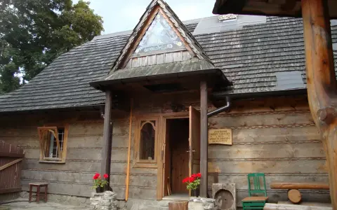 Drewniany budynek muzeum górali i zbójników z charakterystycznym trójkątnym okienkiem nad wejściem.