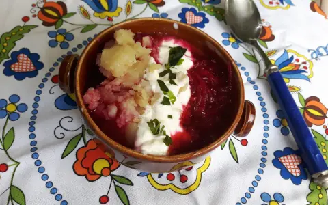 Pyszny przepis na barszcz czerwony z ziemniakami, podany z kleksem śmietany i posypany szczypiorkiem. Idealny na chłodne dni.
